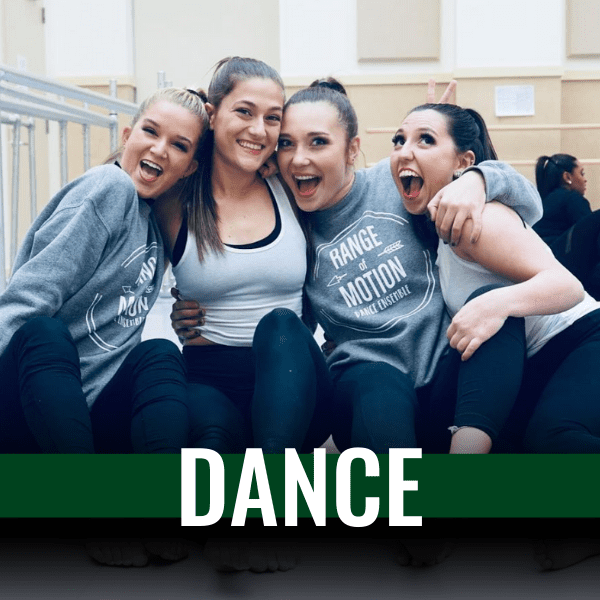 four women hugging, sitting on the floor of a dance studio