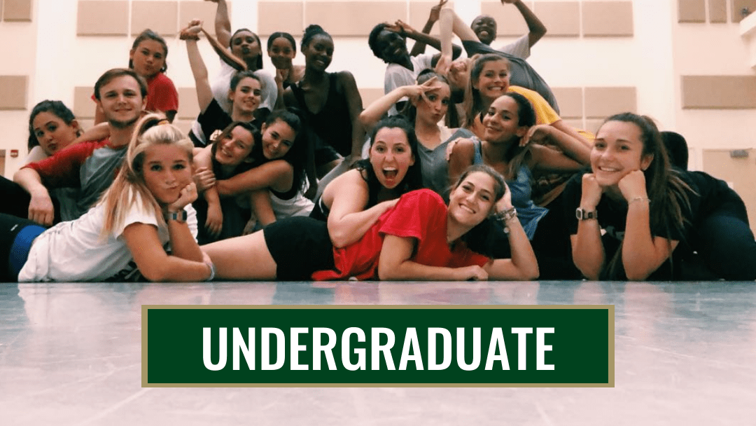 large group of dance students in the dance studio sitting on the floor and making fun faces