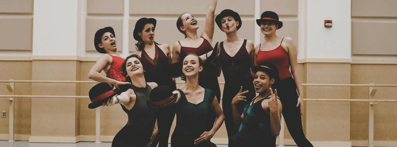 Group of students standing in the middle of a studio smiling and posing