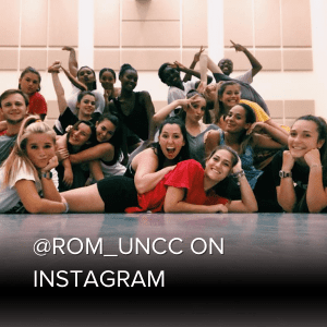 group of students smiling together in the dance studio sitting on the floor