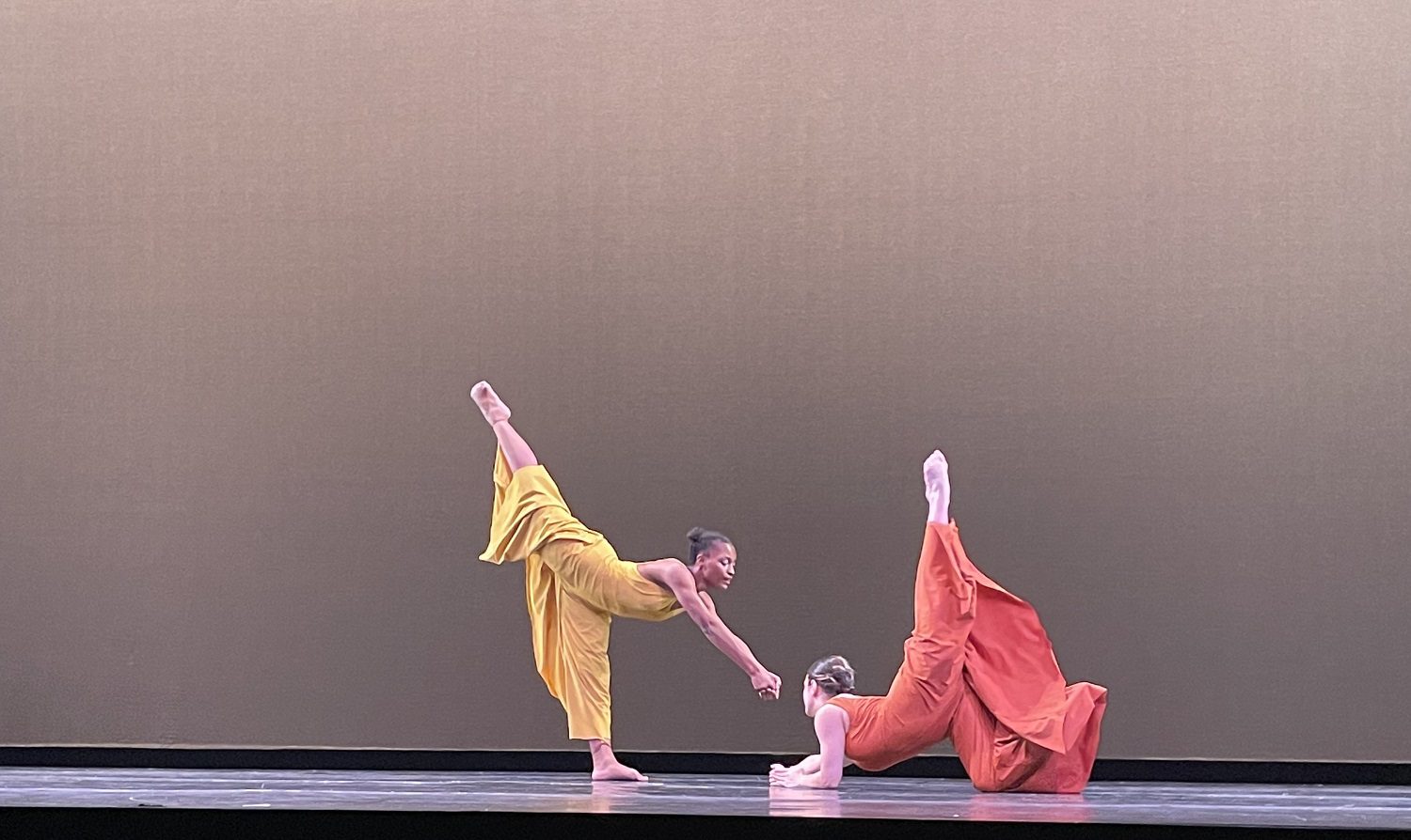 two students performing on stage.