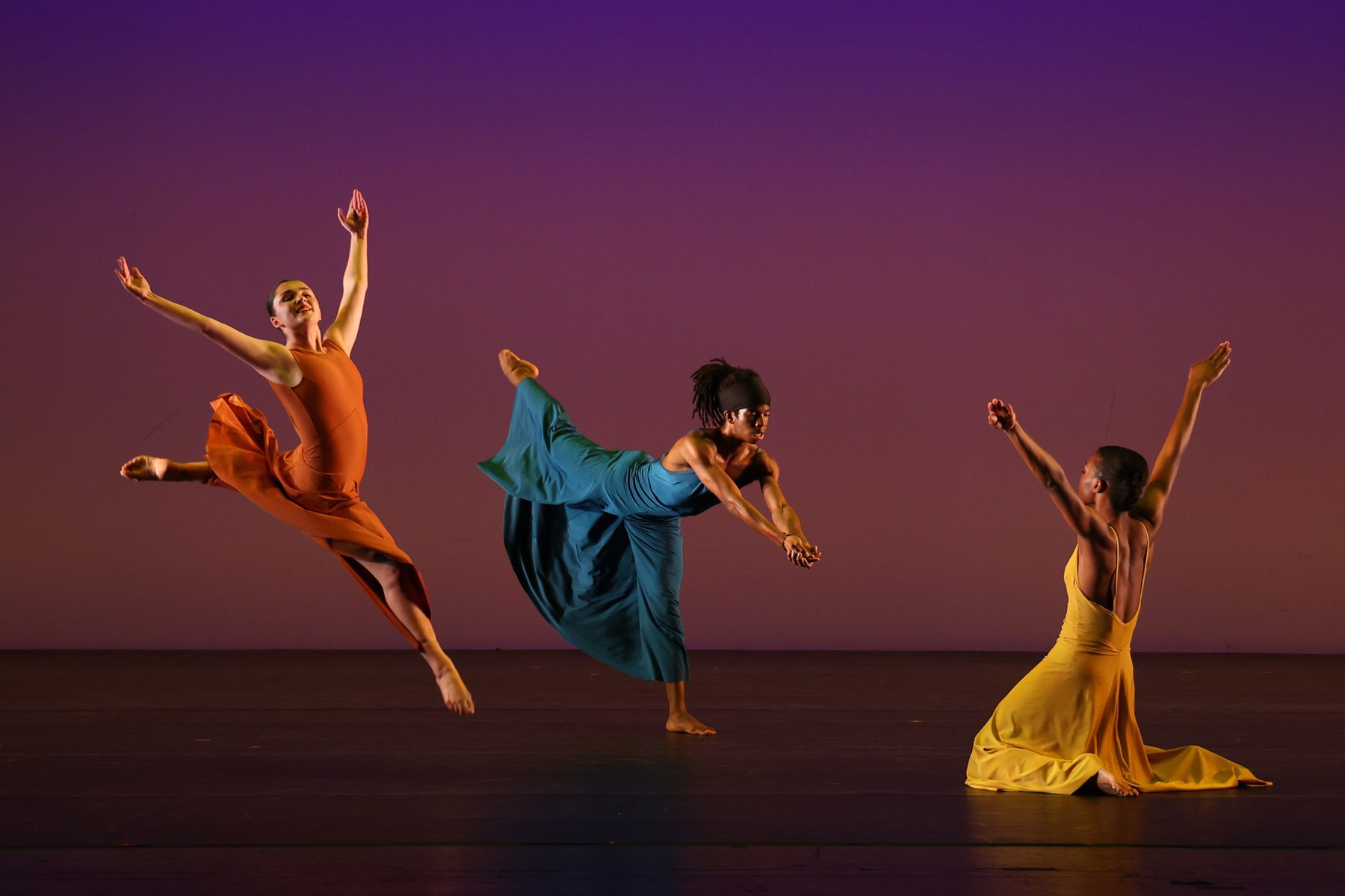 Alabi Orisedele in the center of three dancers performing on stage