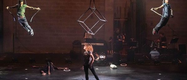 Aerialists on a dark lit stage