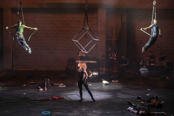 Aerialists on a dark lit stage