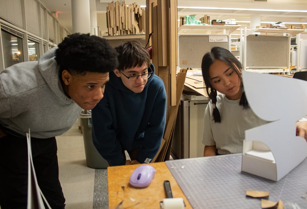 Three students working in the architecture studios looking at a project