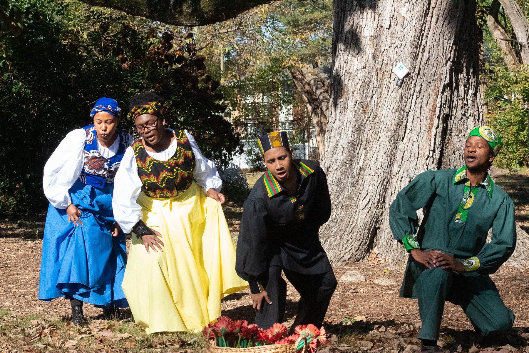 students dancing at a large oak tree