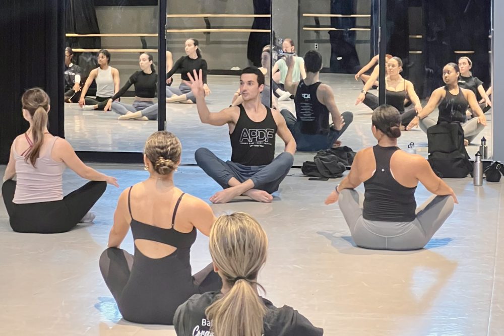 Lorenzo teaching a masterclass, dance students warming up on the floor